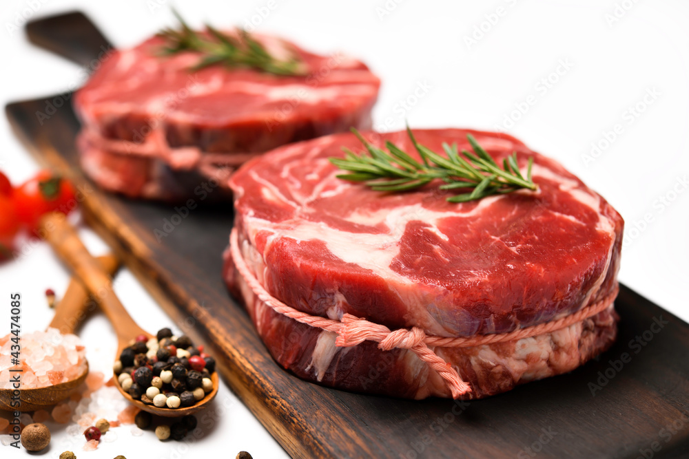 Fresh raw beef meat with ingredients for cooking in the kitchen on white table