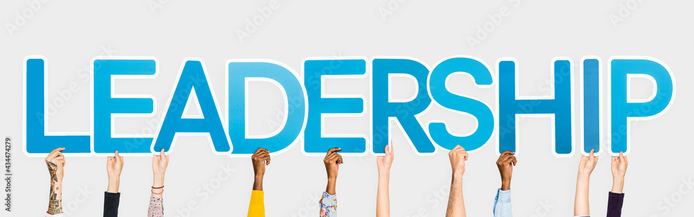 Hands holding up blue letters forming the word leadership Hands holding up blue letters forming the word leadership