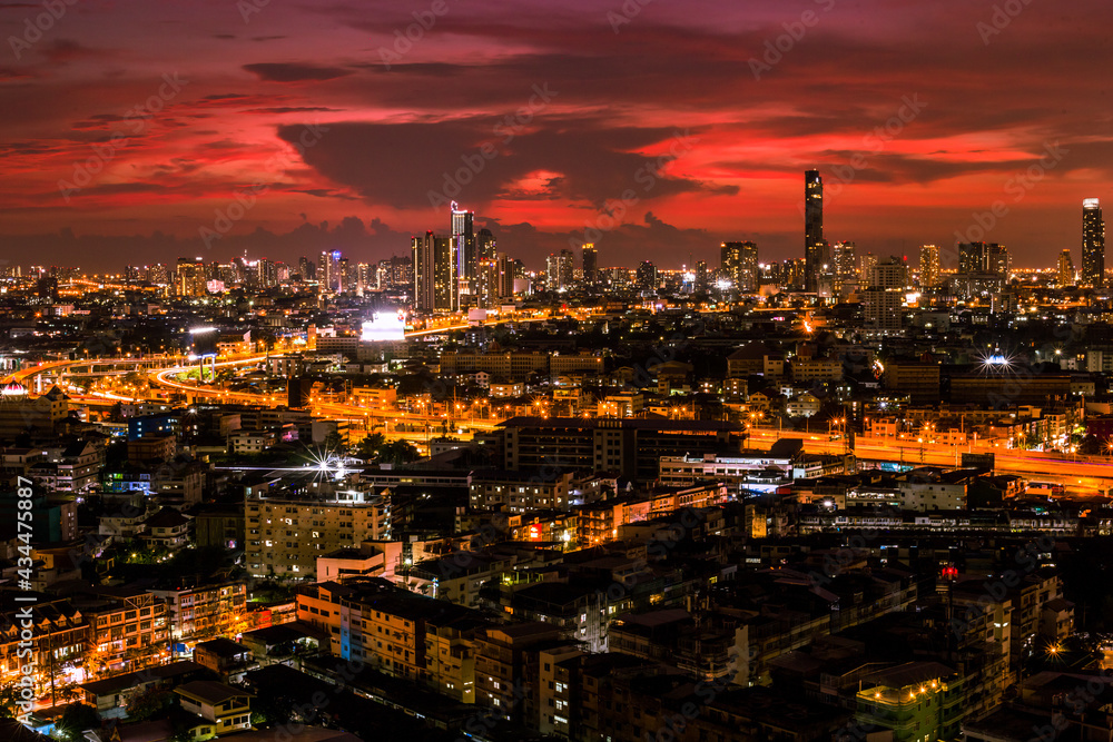 The high angle background of the city view with the secret light of the evening, blurring of night lights, showing the distribution of condominiums, dense homes in the capital community