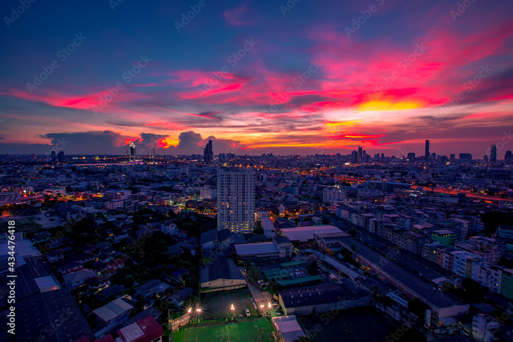 Obraz premium The high angle background of the city view with the secret light of the evening, blurring of night lights, showing the distribution of condominiums, dense homes in the capital community