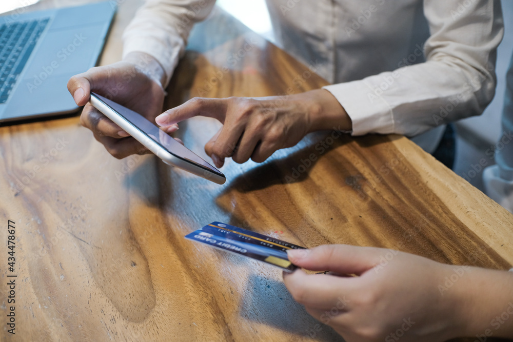 Woman holding credit card and using laptop computer. Online shopping concept.