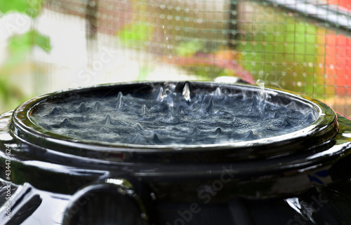 Rainwater harvesting. A collection tank full of rain water, overhead view. A drop rises up in the middle of ripples.