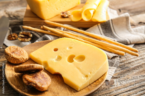 Composition with tasty cheese and snacks on wooden background, closeup