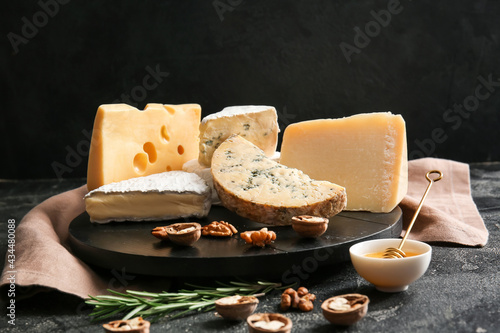 Cuadro en lienzo Tray with different types of cheese, walnuts and honey on dark background