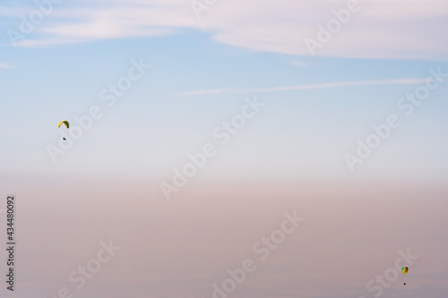Paraglider silhouette flying on blue sky background. Nature landscape. Concept: adventure, art, travel. Blue sky background. Ushkonyr plateau, Kazakhstan. Travel in Kazakhstan concept.