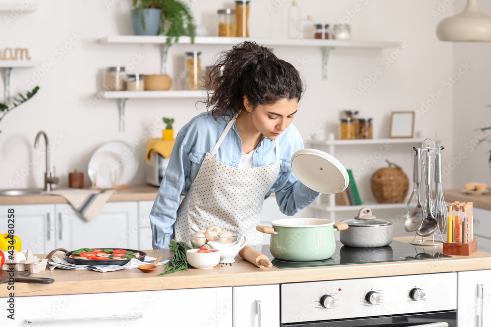 Young woman cooking in kitchen