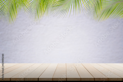 Empy floor wooden perspective with coconut palm leaves wall white pain concrete cement room display. room white blank with wooden table. background summer tourist travel holidays tropical.