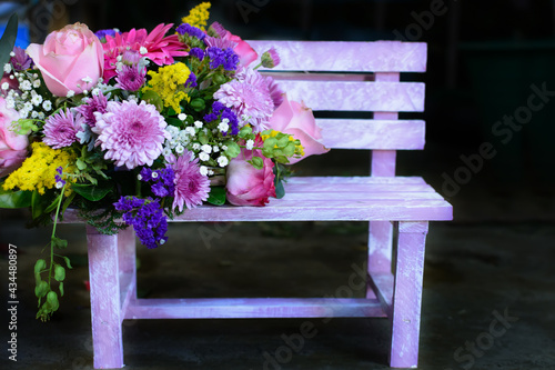 Bouquet of flowers on a small wooden bench.