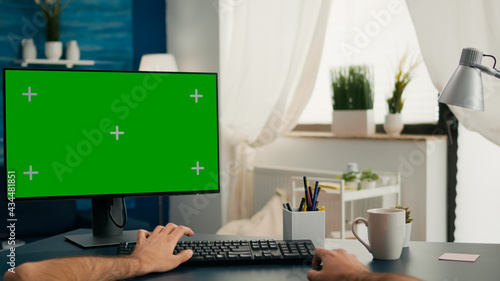 Pov of man hands sitting on office desk using computer with mock up green screen chroma key working © DC Studio