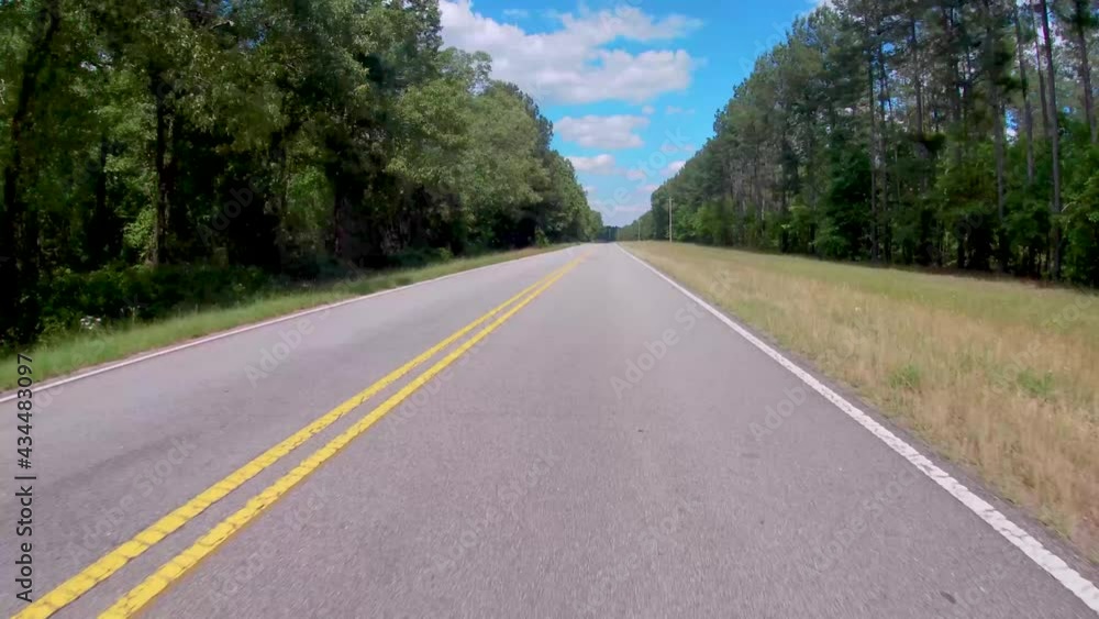 FPV Driving on a country rural road with lush green forest and blue sky with clouds no traffic FPV Driving on a country rural road with lush green forest and blue sky with clouds no traffic