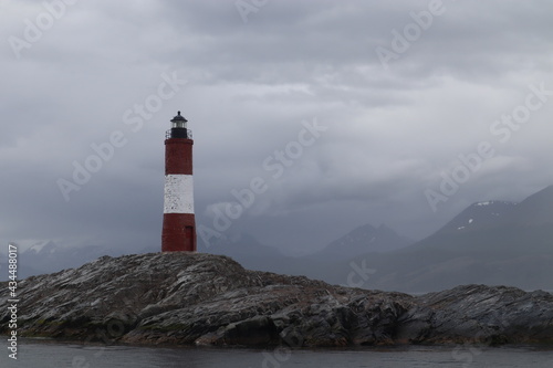 Lighthouse on the end of the world, famous sign in the beagle channel, red and white house to orientate on the ocean, landmark near by the coastline in tierra de fuego patagonia argentina