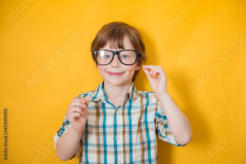 Fototapeta Naklejka Na Ścianę i Meble -  Smiling kid boy wearing casual clothes doing gesture with hands, poses against yellow background