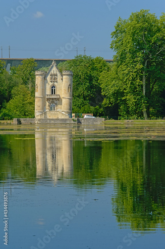 Castle of the white queen in neo gothic style, reflecting in the water of Comelles lake in Coye-la-Forêt 