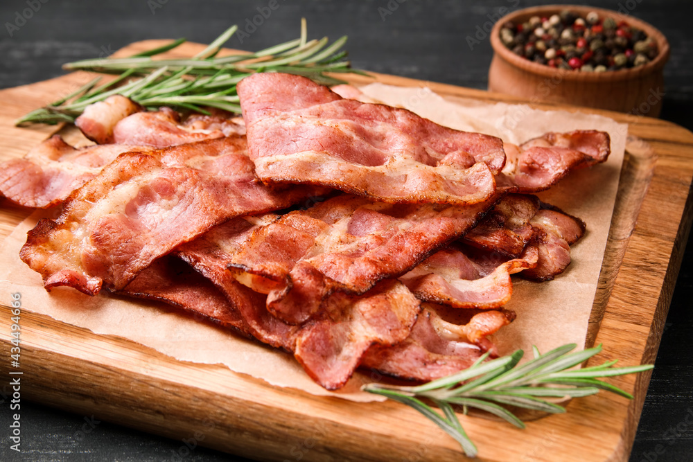 Hot fried bacon with rosemary on a black background. Hot fried bacon with rosemary on a black background.