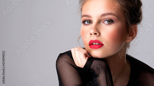 Beautiful photoshopped brown-hair girl. Attractive girl with bright makeup looking at the camera.
