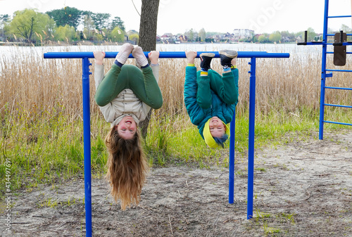 Two young caucasian children sibling having fun on the sport playground.