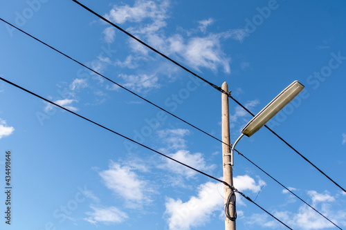 Wallpaper Mural A street lamppost with wires. Wooden pole with a lantern and electric cables against a blue sky. Torontodigital.ca