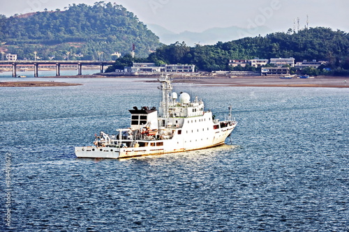 Seagoing vessels, tugboats at the port under cargo operations and underway. Port of Fangcheng, China. September, 2020 photo