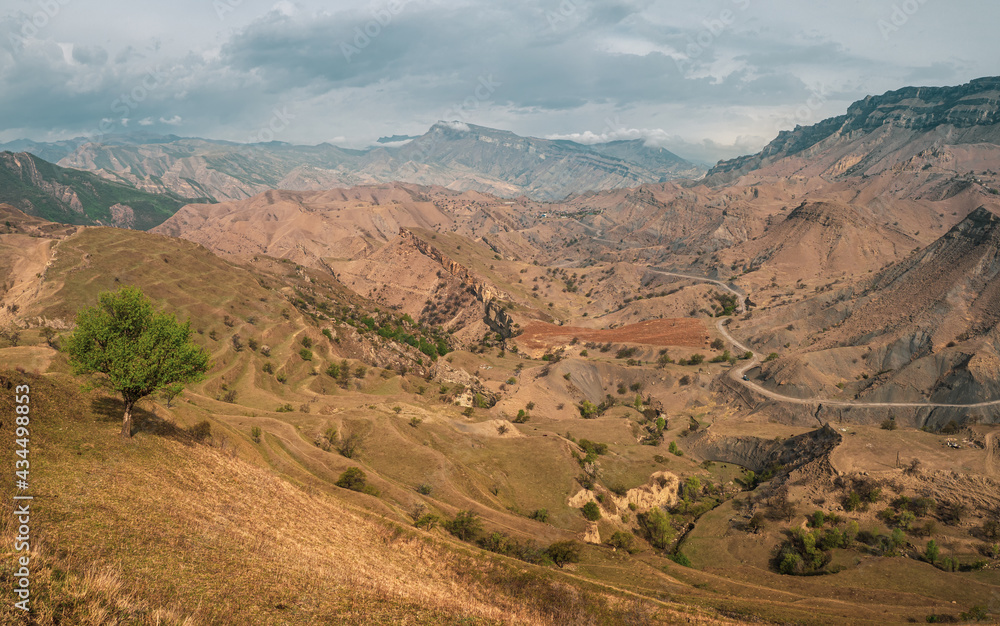 Panorama of a mountain valley with a serpentine road.