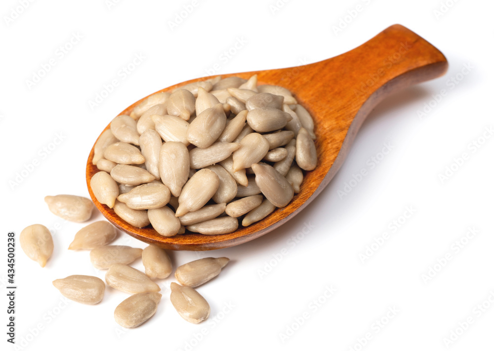 peeled sunflower seeds in the wooden spoon, isolated on white background peeled sunflower seeds in the wooden spoon, isolated on white background