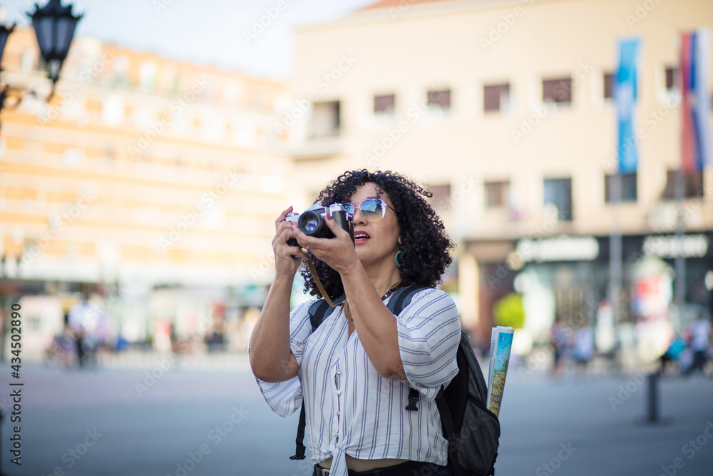 Woman taking photo in the city with camera.