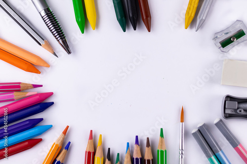 Top shot of crayon, pencil colors, paint brush, sharpeners, eraser -Classroom concept. photo