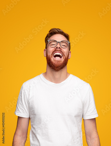 Laughing young bearded man in studio