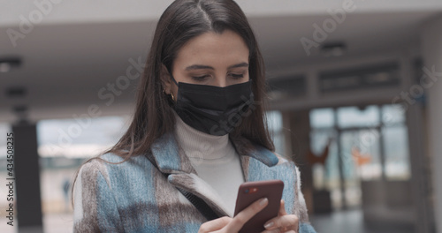 Woman with face mask using a smartphone