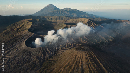 Drone view of Mount Gunung Bromo volcano in East Java, Indonesia. Mount Bromo is active volcano in clouds of smoke with crater in depth photo