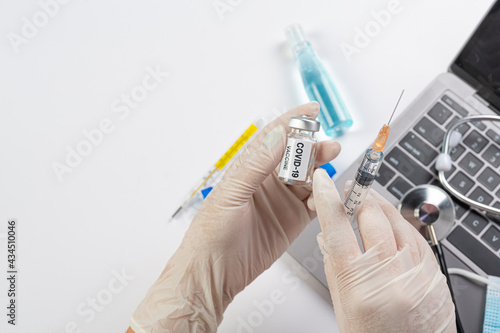 Close up a vial of covid-19 vaccine in hand of a scientist or doctor