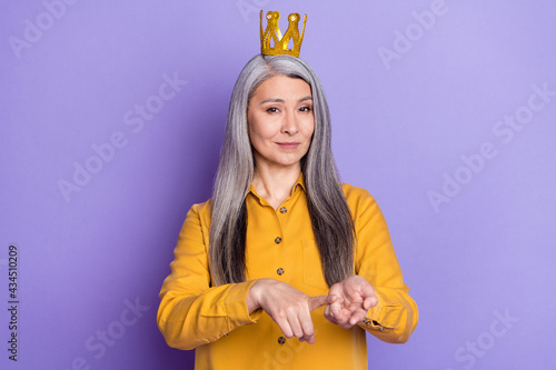 Portrait of attractive strict woman wearing crown saying pretense isolated on bright violet purple color background