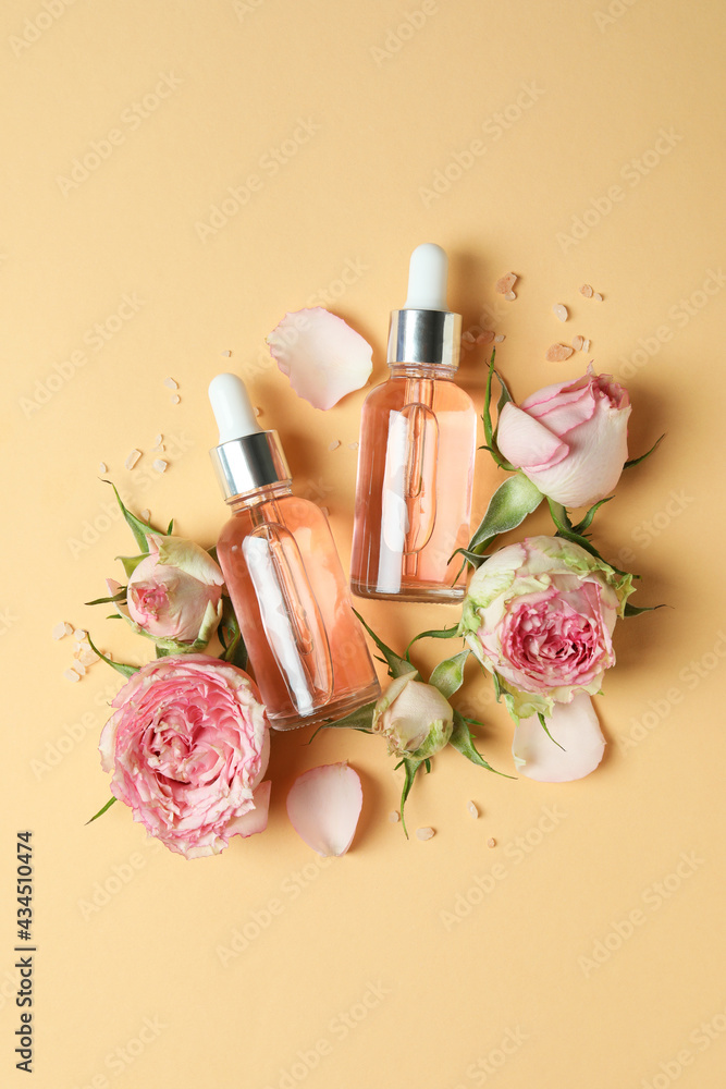 Skin care concept with essential rose oil on beige background, top view Skin care concept with essential rose oil on beige background, top view