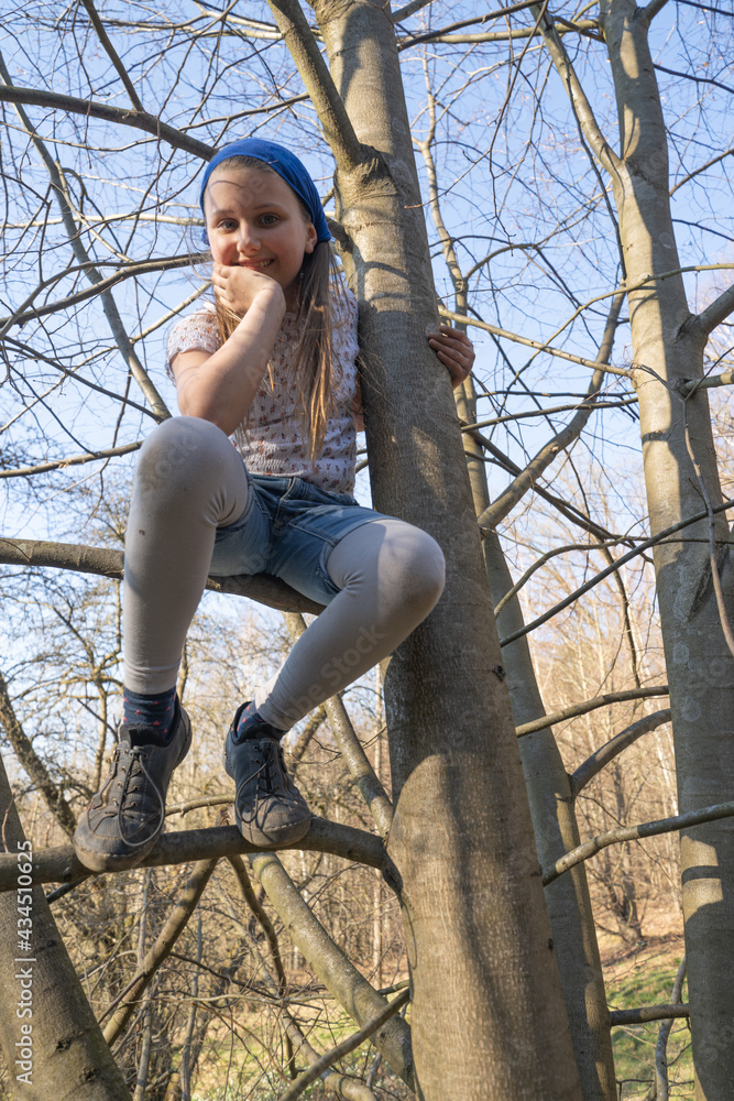 Foto de Junges, hübsches und wildes Mädchen im Wald beim Klettern in Bäumen. Sie liebt es auf
