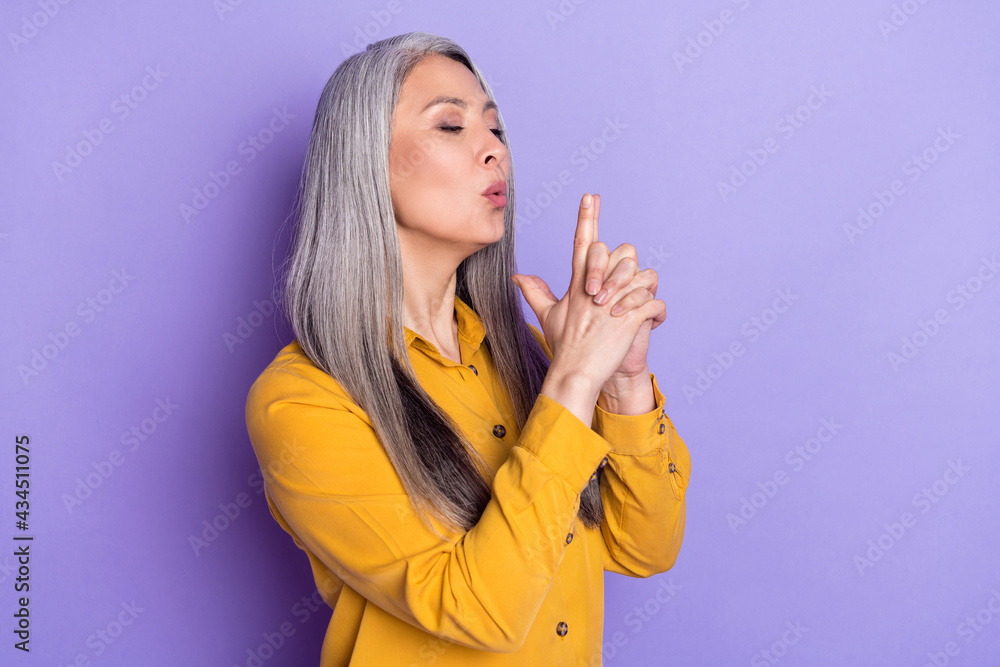 Profile side view portrait of attractive cruel woman showing gun sign
