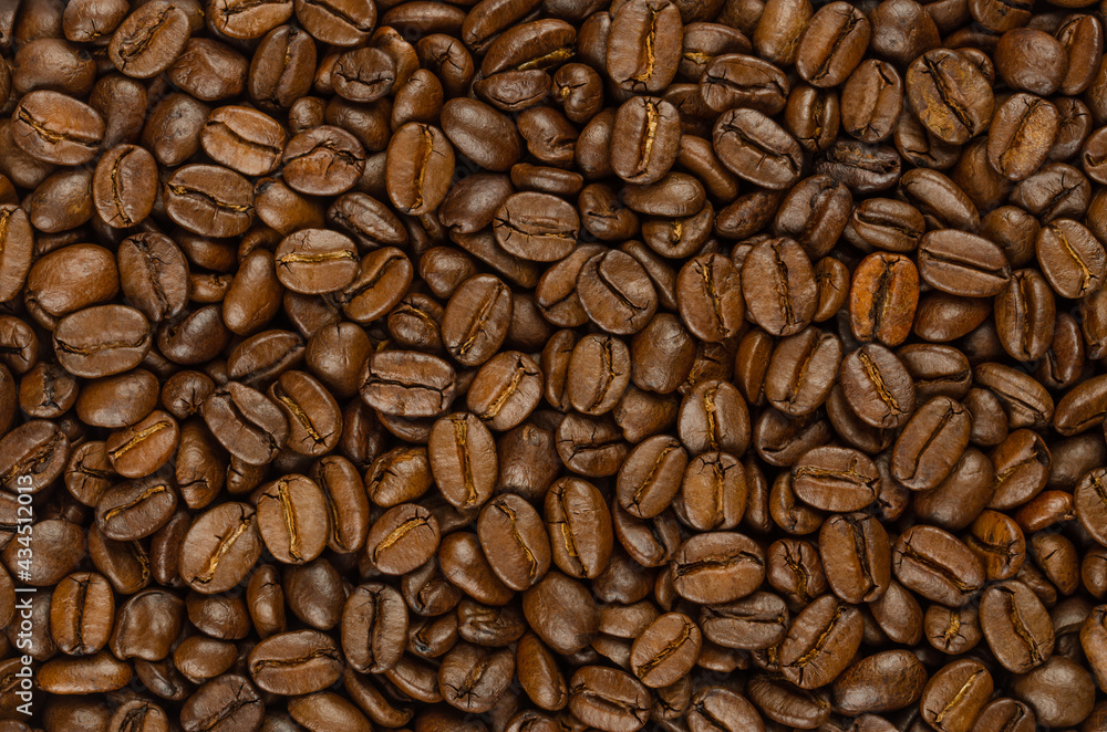 Obraz premium Roasted coffee beans, background, from above. Dark brown, roasted seeds of berries from Coffea arabica, also known as Arabian, mountain or arabica coffee, ready to ground. Backdrop. Macro, food photo.