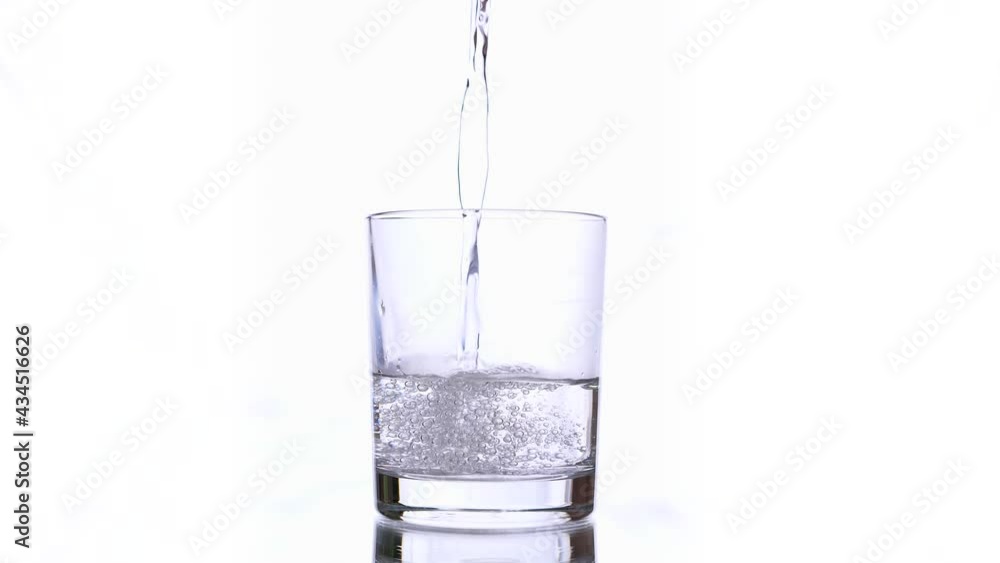 Water being poured into Glass against White Background. Isolated conceptual footage Water being poured into Glass against White Background. Isolated conceptual footage