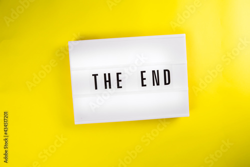 Lightbox with message THE END isolated on yellow background. Concept of finish, closure, end of year, diet, clearance, goal achievement, positive result, end coronavirus disease quarantine outbreak