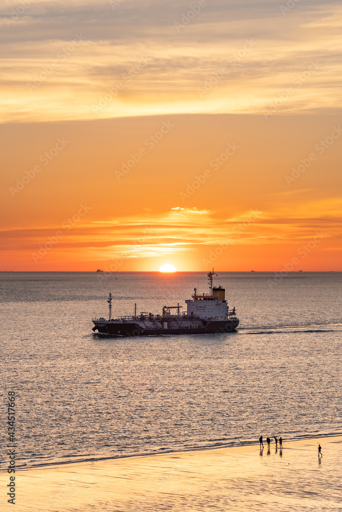 Boat passing by the beach in Vlissingen Holland in sunset