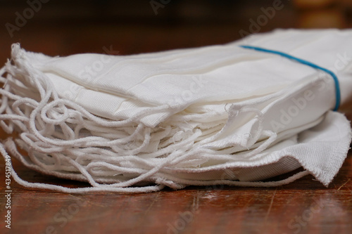 A stack of medical protective masks on scratched wooden table