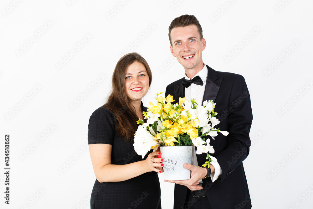 Couple in black clothes with bouquet of flowers smiling to camera Couple in black clothes with bouquet of flowers smiling to camera
