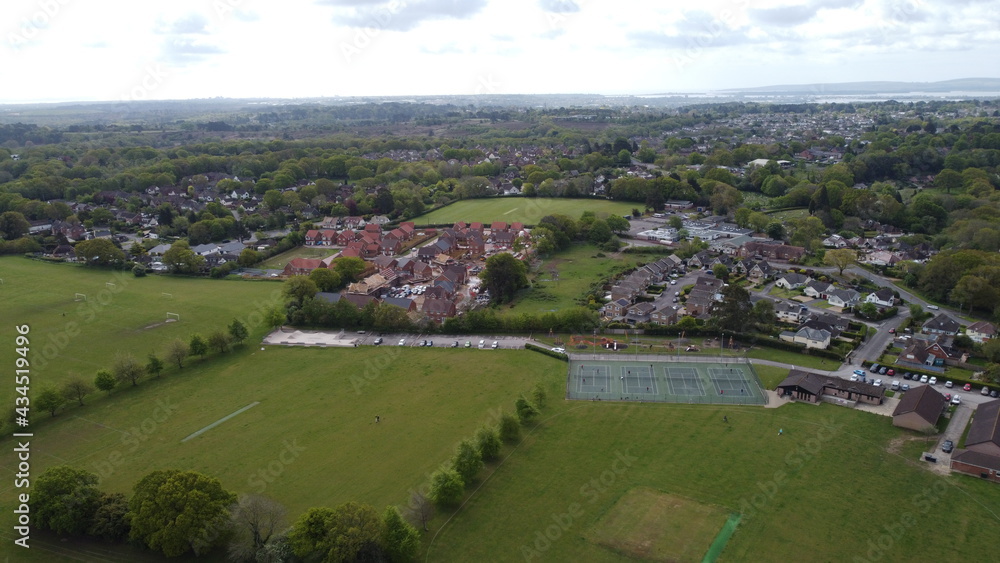 Aerial view of playing fields, trees and new housing development