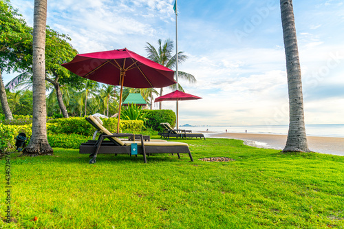 Fototapeta Naklejka Na Ścianę i Meble -  Umbrella with chair with sea beach background and sunrise in morning