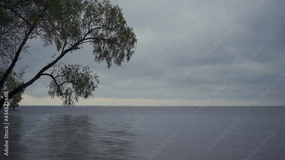 Rainy day on the river. Raindrops on the water surface Rainy day on the river. Raindrops on the water surface