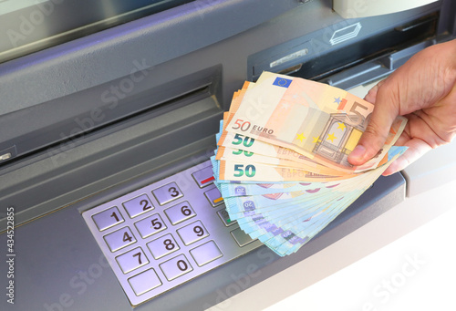Fotografie hand with money just withdrawn from the ATM machine and the numbers on the numer