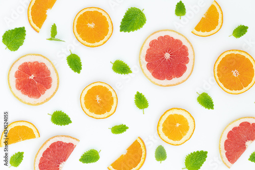 Summer bright background with oranges  grapefruites and green leaves on the gray surface