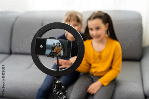 two school girl bloggers. Emotionally gestures. camera. Record vlog and blog subscribers. Record video lesson for Internet. Use camera with tripod.
