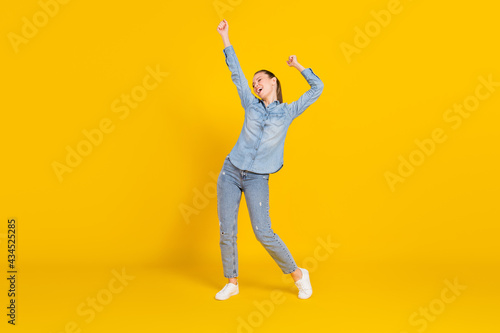 Full length body size photo smiling girl laughing dancing at party overjoyed isolated vivid yellow color background