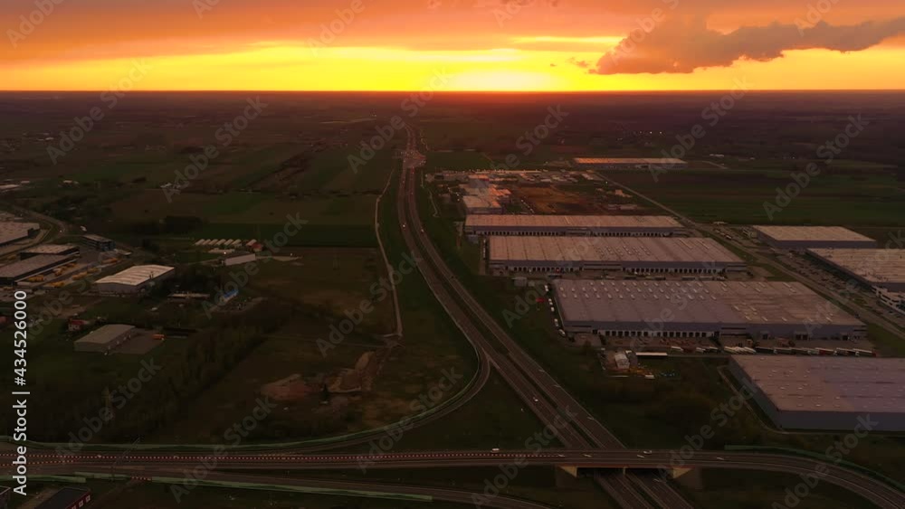 Semi-trailers trucks are waiting for the loading and unloading of goods at the warehouse ramps in a large logistics park with a loading hub. Aerial view at sunset Semi-trailers trucks are waiting for the loading and unloading of goods at the warehouse ramps in a large logistics park with a loading hub. Aerial view at sunset