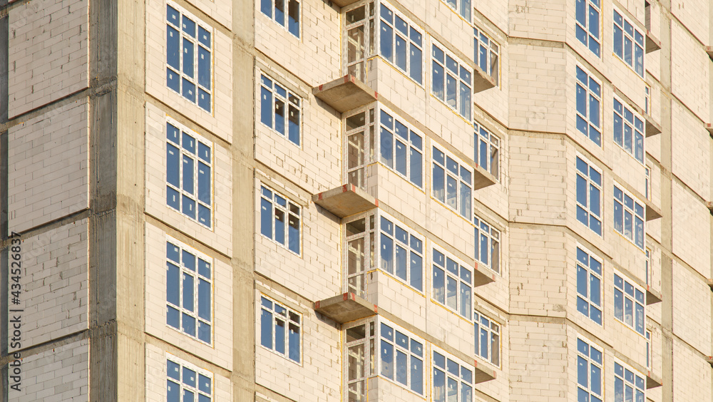 Details of house under construction. Windows and balconies. Construction of multi-storey residential building. Crane build multi-storey residential house. Modern residential construction. Details of house under construction. Windows and balconies. Construction of multi-storey residential building. Crane build multi-storey residential house. Modern residential construction.