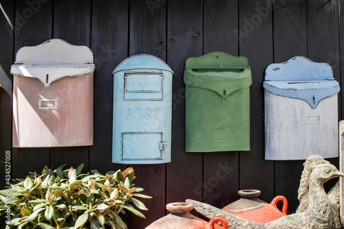 decorative mailboxes hanging on a shabby wall